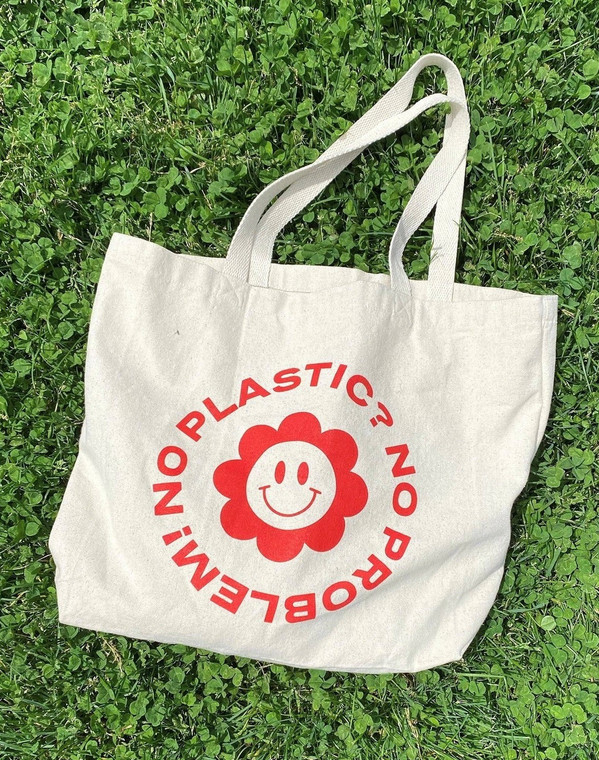 A canvas tote with wording "no plastic? no problem!" and a smiling flower
