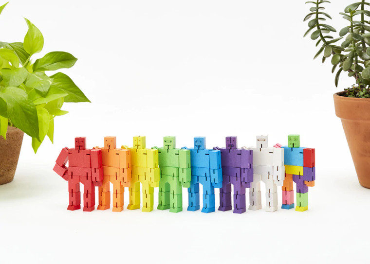 Eight lined up wooden micro cubebot figurines.