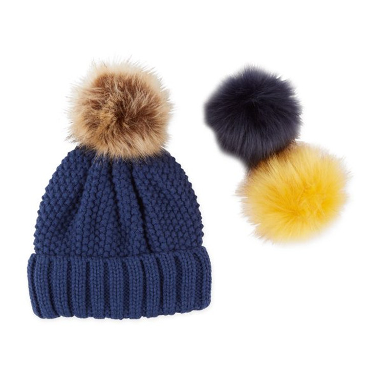 Navy blue knit beanie with light brown, navy, and yellow interchangeable pom poms.
