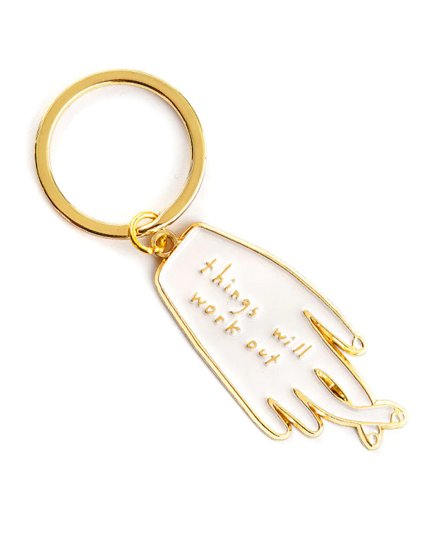 A keychain shaped as a hand with fingers crossed.