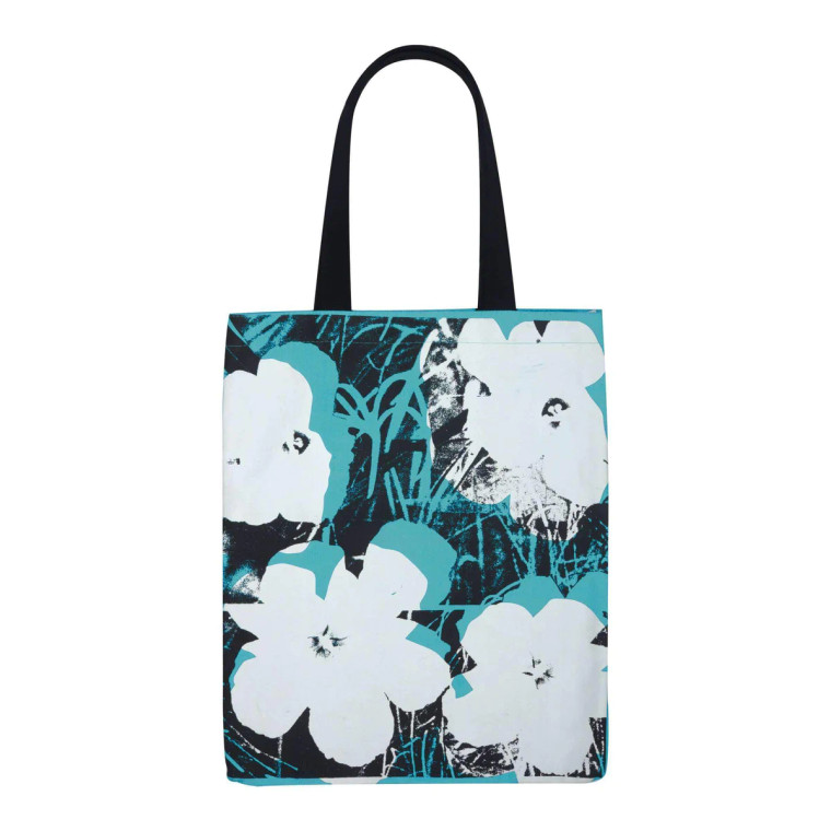 A light blue canvas tote bag with black handles silkscreened with white, black and blue flowers.