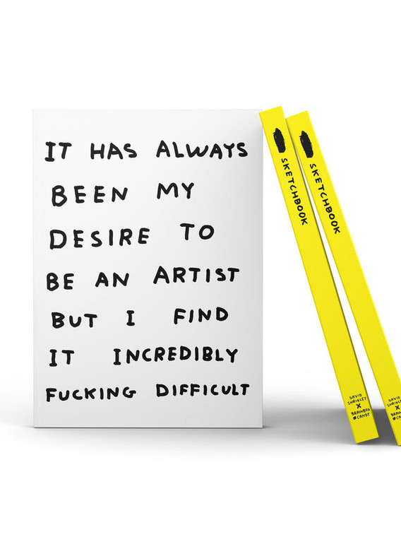 White notebook with black text: "it has always been my desire to be an artist but I find it incredibly fucking difficult".