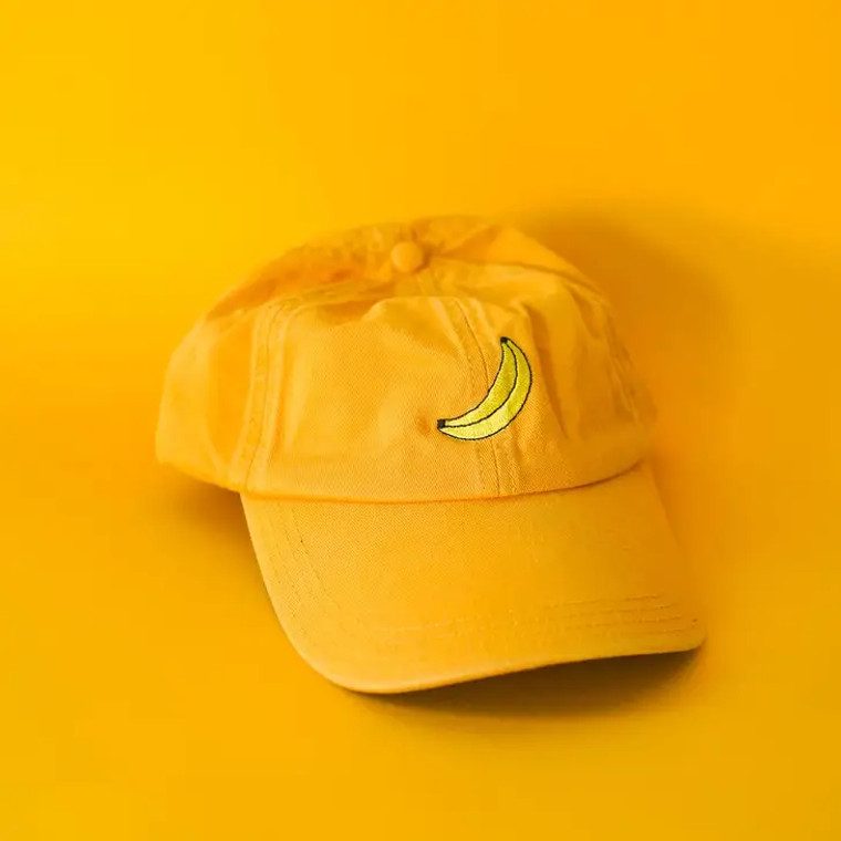 Yellow cap with an embroidered banana, front view.