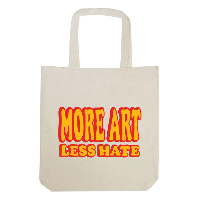 Front view, canvas tote with text in bright yellow lettering, red shading.
text: more art less hate.