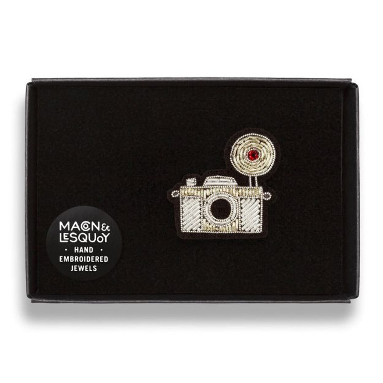 The embroidered brooch placed inside its black gift box.