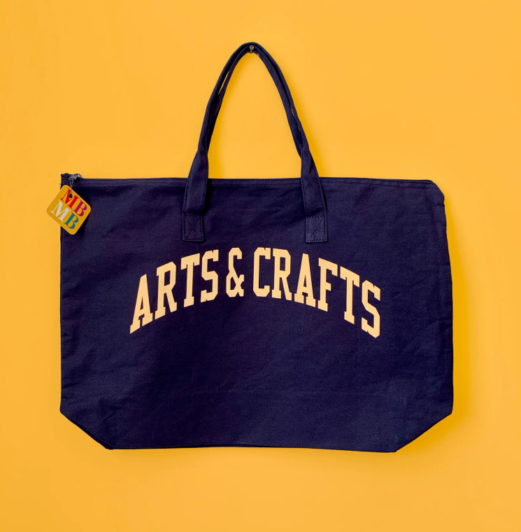 navy blue tote with cream colored letters, text: arts & crafts.