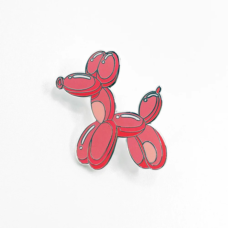 Balloon dog shaped enamel pin in coral
