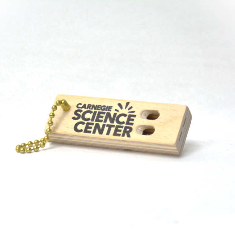 A small wooden whistle with the Carnegie Science Center logo.