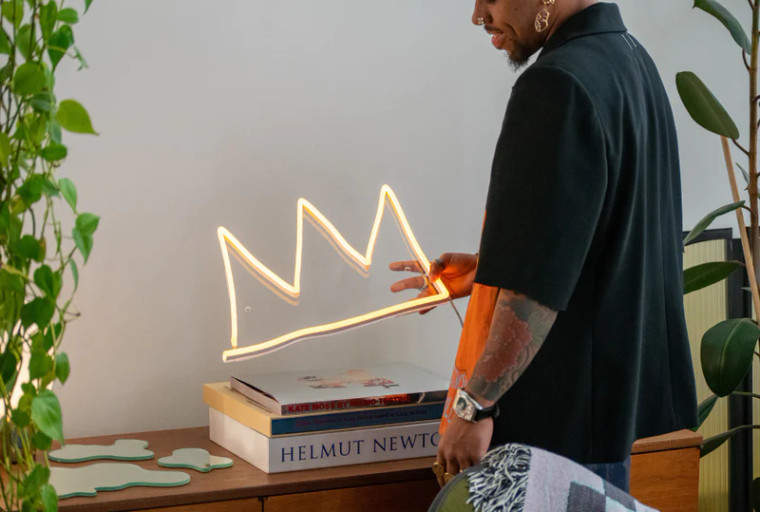 A person holding the yellow crown shaped LED neon.