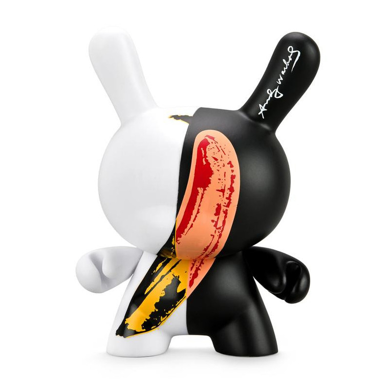 A bunny shaped black and white vinyl figure with a yellow banana on it
