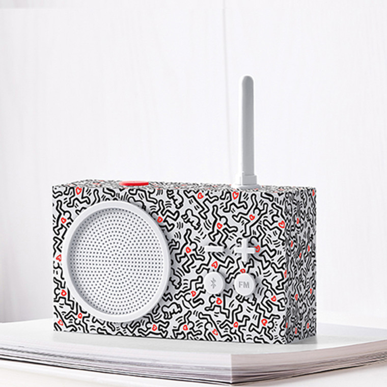 White small rectangular radio with an antenna, imprinted with black Keith Haring artwork.
