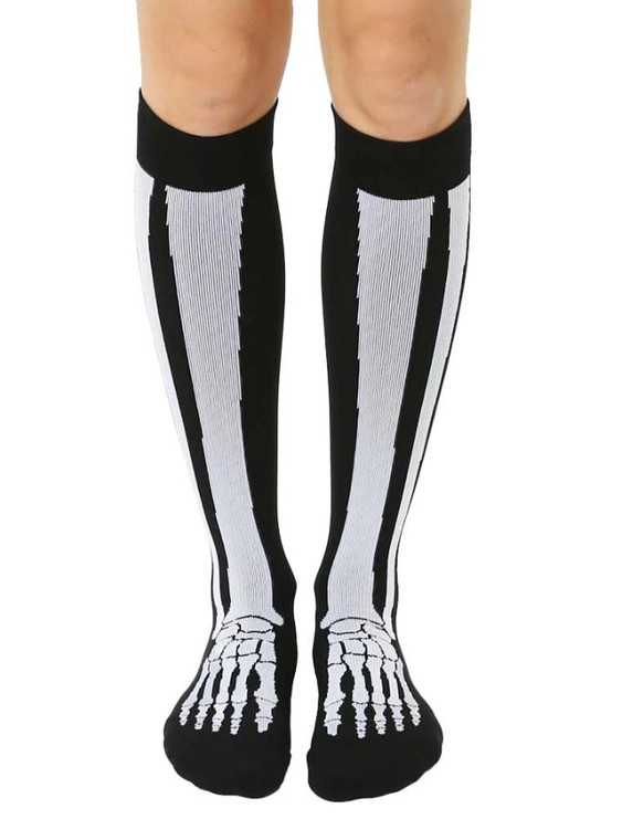 The legs from the knee down of a person wearing knee-high black socks with an image of leg and foot bones.