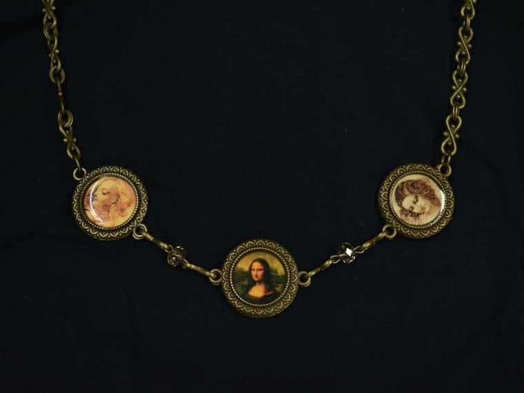 A necklace of a bronze- colored chain and three centerpieces featuring artwork by Leonardo Da Vinci.