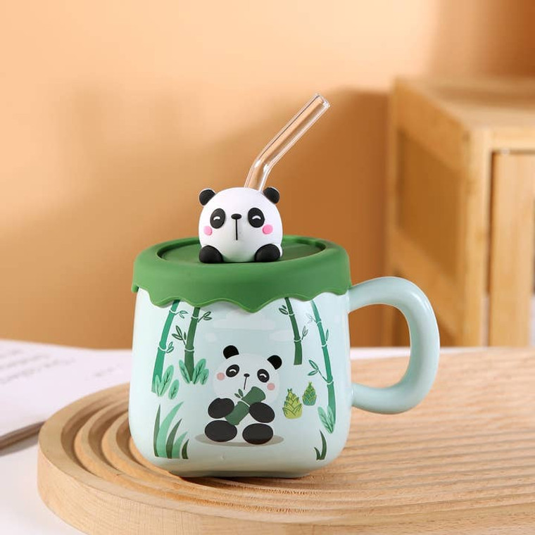 light green mug with cartoon panda eating bamboo printed on the front, and a silicone lid with 3D panda and glass straw