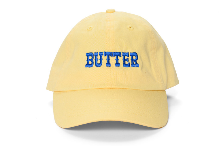 pigment dyed yellow baseball cap, blue embroidered text "butter"