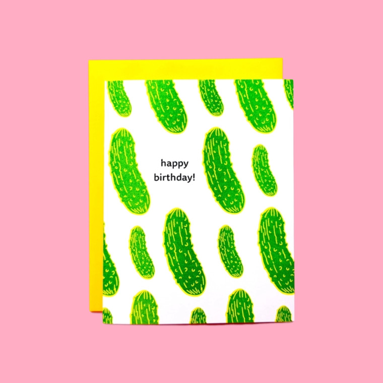 White greeting card, green pickle illustration, text in black "happy birthday"