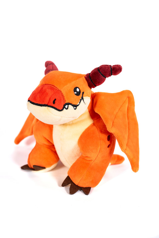 orange dragon plush sitting against a white background