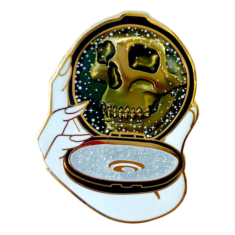 Compact shaped enamel pin, black with glitter color, in place of the mirror a skull is shown.