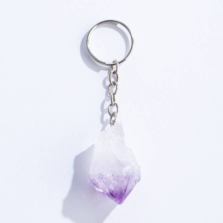 Carved Amethyst pointed crystal attached to a silver keychain ring.  3 and 1/4 inches in length.