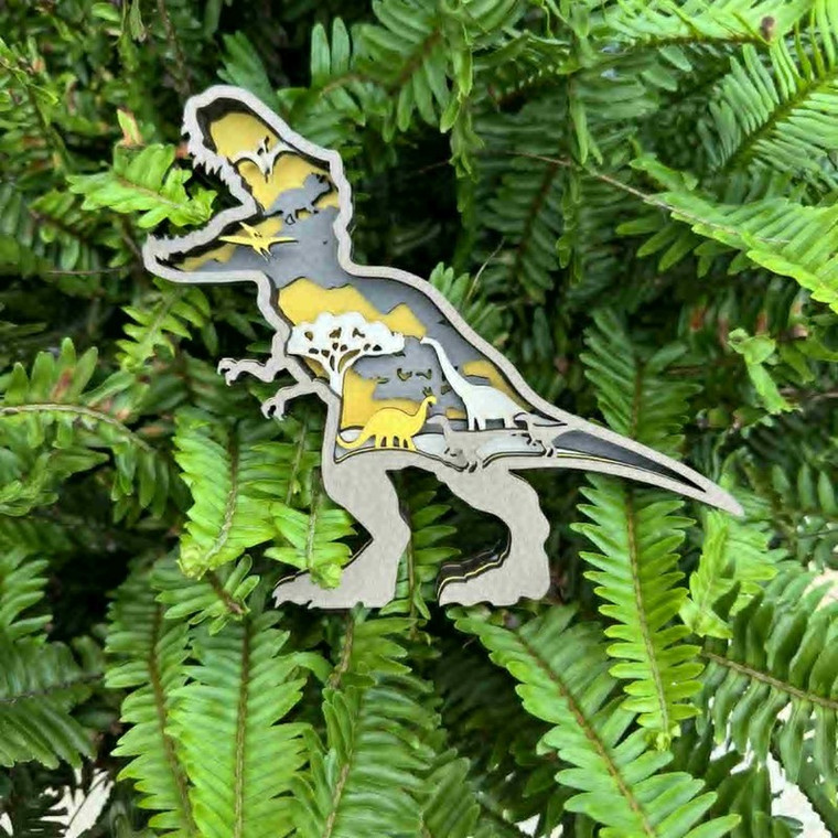 A wooden T-Rex standee features a layered 3-d center in which a forest scene and several other dinosaur silhouettes can be seen. Yellow and gray tones are featured in the background.