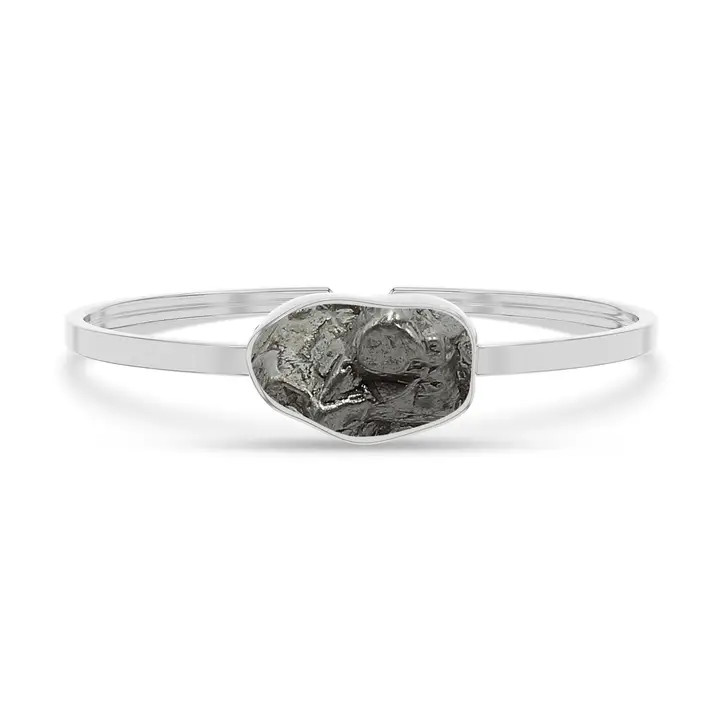 A cuff braclet featuring a meteorite set in sterling silver