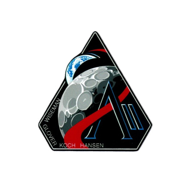 A magnet in the shape of the triangular mission patch of Artemis II, featuring illustrations of the Earth and Moon as well as the surnames of all four crew.