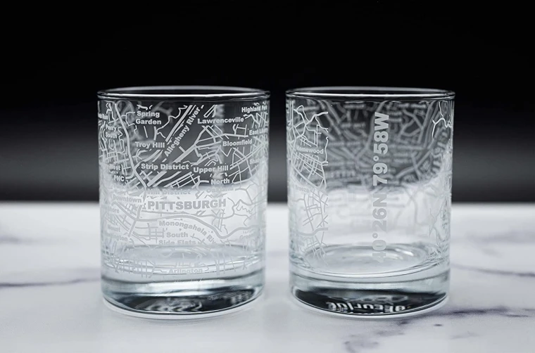 A pair of whiskey glasses etched with a Pittsburgh Street map