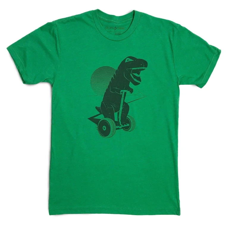 An illustration of an inflated T-rex  riding a Segway cruises in front of a sun motif. The shirt is a kelly green while the screen print image is in black.