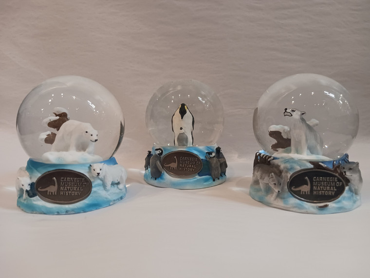 An image of all three snow globes. They feature a polar bear, penguin and chick, and wolf. Their bases are arctic blue with three-dimensional additions of their respective animals.