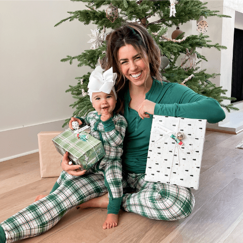 Mom and child with presents infront of a tree goldng gifts and customized holiday Chapstick. Mom and child with presents infront of a tree goldng gifts and customized holiday Chapstick.