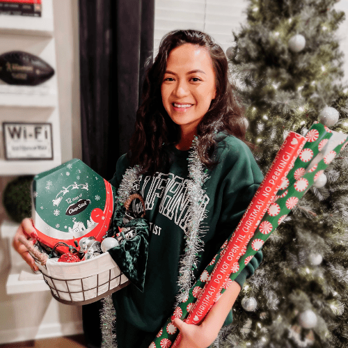 Young ladyy with a sweatshirt holding 12 days of chapstick advent calendar infront of a christmas tree. Young ladyy with a sweatshirt holding 12 days of chapstick advent calendar infront of a christmas tree.