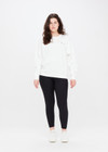 THE UPSIDE women's white Saturn Arrow Sweater is an organic cotton fleece jumper with a relaxed, oversized fit. It features a soft rib at the neckline, handcuffs and cuffs.
