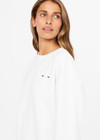 THE UPSIDE women's white Saturn Arrow Sweater is an organic cotton fleece jumper with a relaxed, oversized fit. It features a soft rib at the neckline, handcuffs and cuffs.