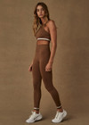 THE UPSIDE women’s brown mid-rise Form Seamless 25 Inch Midi Pant made with Form Seamless fabric features ribbed waistband, white stripe on ankles and moisture wicking properties; ideal for yoga, pilates or barre.