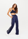 THE UPSIDE womens navy mid rise Celeste Pant made with slinky fabrication features a relaxed straight leg silhouette, elasticated waistband, drawcord, and white stripe down side seams.