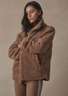 THE UPSIDE women's brown oversized Hudson Jacket made with faux shearling features a high neck collar with zipper, drawcord at waist and pockets. Fully lined, designed for winter.