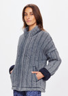 THE UPSIDE women's denim-blue Nouveaux Daria Jacket made with organic cotton jersey fabrication is an oversized zip-through quilted jacket featuring twin needle stitch detailing, snap buttons and printed indigo paisley lining.