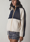 THE UPSIDE women's white and navy Harlow Zip Through Jacket made with double sided recycled fleece features a full zip with contrasting mocha binds, white and navy colour blocks, and elastic at waist and cuffs