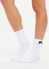 THE UPSIDE women's white Lavalliere Sock is made in breathable cotton. The crew sock is designed with jacquard arrow on the sole and navy satin bows at the edges. Designed for all types of movement.