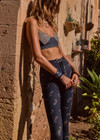 THE UPSIDE women's dark navy paisley Vadella 28in Yoga Pant is made form recycled textured rib fabric with moisture wicking properties. The mid rise legging features a striped elastic drawcord through the waist.