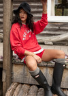 THE UPSIDE women's red Ranchero Saturn Crew Sweater is made from organic cotton. The oversized sweater features print western logo. Designed for lifestyle wear.