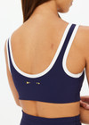 THE UPSIDE women's navy Silverstone Harley Scoop Sports Bra is designed for a supportive fit featuring a recycled rib fabrication and removable bust cups. Ideal for yoga and pilates.