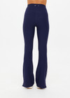 THE UPSIDE women's navy recycled peached Florence Flare Pant is a high-rise pant in a breathable fabric, featuring cream side stripes. Perfect for pilates.