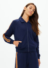 THE UPSIDE women's navy Vitesse Pari Zip Jacket comes in a slinky fabrication with mesh side tapes in contrast orange and side pockets. Designed for everyday leisure.