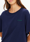 THE UPSIDE women's navy organic cotton Sammi Tee is an oversized fit and features The Upside logo on front and a printed palm tree sunset design on back. Made for lifestyle.