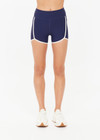 THE UPSIDE women's navy recycled peached Samara 3.5inch Spin Short offers a soft & supportive fit and features side pockets and contrast cream stripes . Made for pilates.