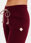 THE UPSIDE women’s maroon organic cotton Le Ski Jojo Knit Jogger features a soft knitted waistband with braided tassel drawcord, side pockets and snowflake design at ankles. Designed for Après-ski and winter wear.