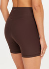 THE UPSIDE women's brown high-waisted Peached 5inch Spin Short offers a soft & supportive fit in recycled peached fabric and features a printed arrow logo on back waistband. Made for pilates & yoga.