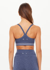 THE UPSIDE women's blue Bowery Baxter Tbar Sports Bra features a scooped neckline with ultraflex recycled fabrication, removeable bust cups and cream embroidered stripes at underbust. Made for yoga & pilates.