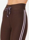 THE UPSIDE women's brown eco tech Oxford 25Inch Legging offers a mid rise with lilac coloured binds down side seams and an elastic drawcord through waist. Made for high impact.